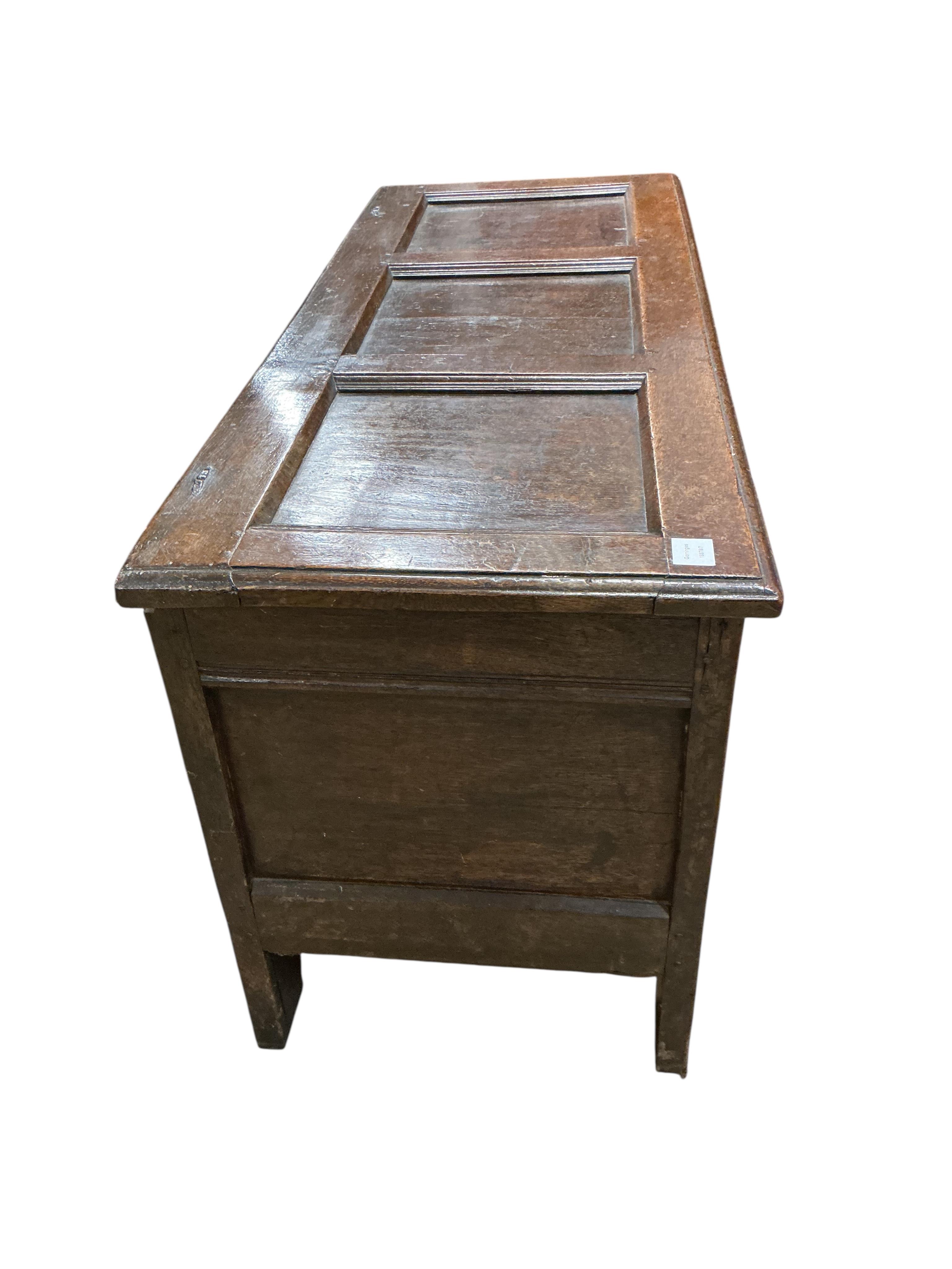 A 17th century oak coffer, the panelled front carved with lozenges, width 126cm, depth 51cm, height 64cm